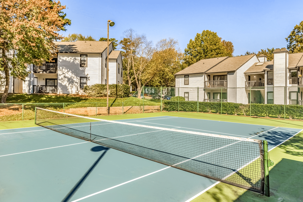 A tennis court is surrounded by apartment buildings at Paces Pointe Apartment Homes, North Carolina, 28105