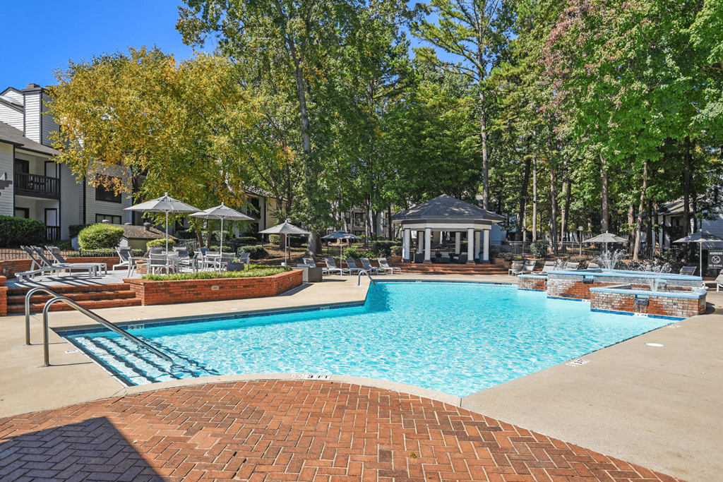 A pool surrounded by trees and a gazebo at Paces Pointe Apartment Homes, North Carolina, 28105