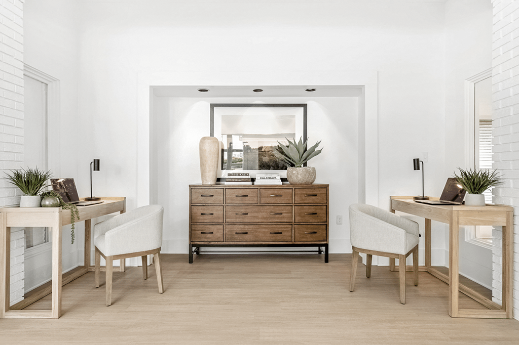 A room with a wooden desk, chair, and dresser with a mirror above it at Paces Pointe Apartment Homes, Matthews, North Carolina
