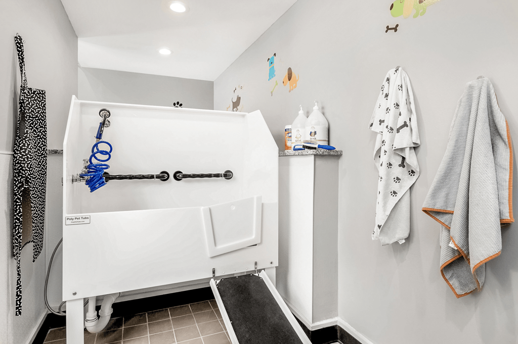 A white bathtub with a blue shower head and faucet at Paces Pointe Apartment Homes, Matthews, North Carolina