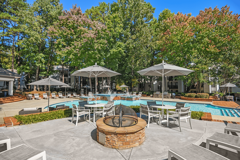 A poolside area with a fire pit in the middle at Paces Pointe Apartment Homes, Matthews, NC, 28105