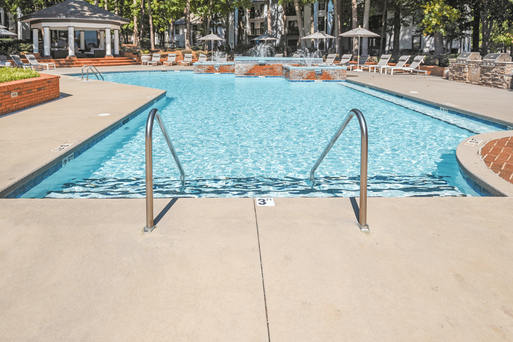 A swimming pool with a ladder in the middle at Paces Pointe Apartment Homes, Matthews, 28105