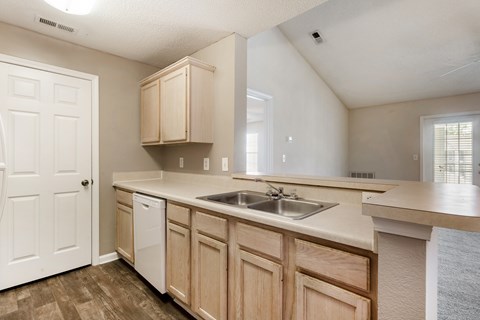 A kitchen with wooden cabinets and a white sink.