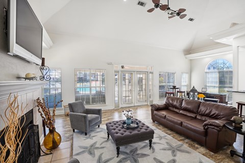 A living room with a brown leather couch and a grey armchair.