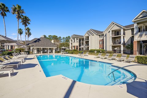 A large swimming pool in front of apartment buildings.