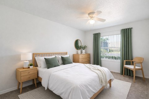 A bedroom with a bed, nightstand, and chair.