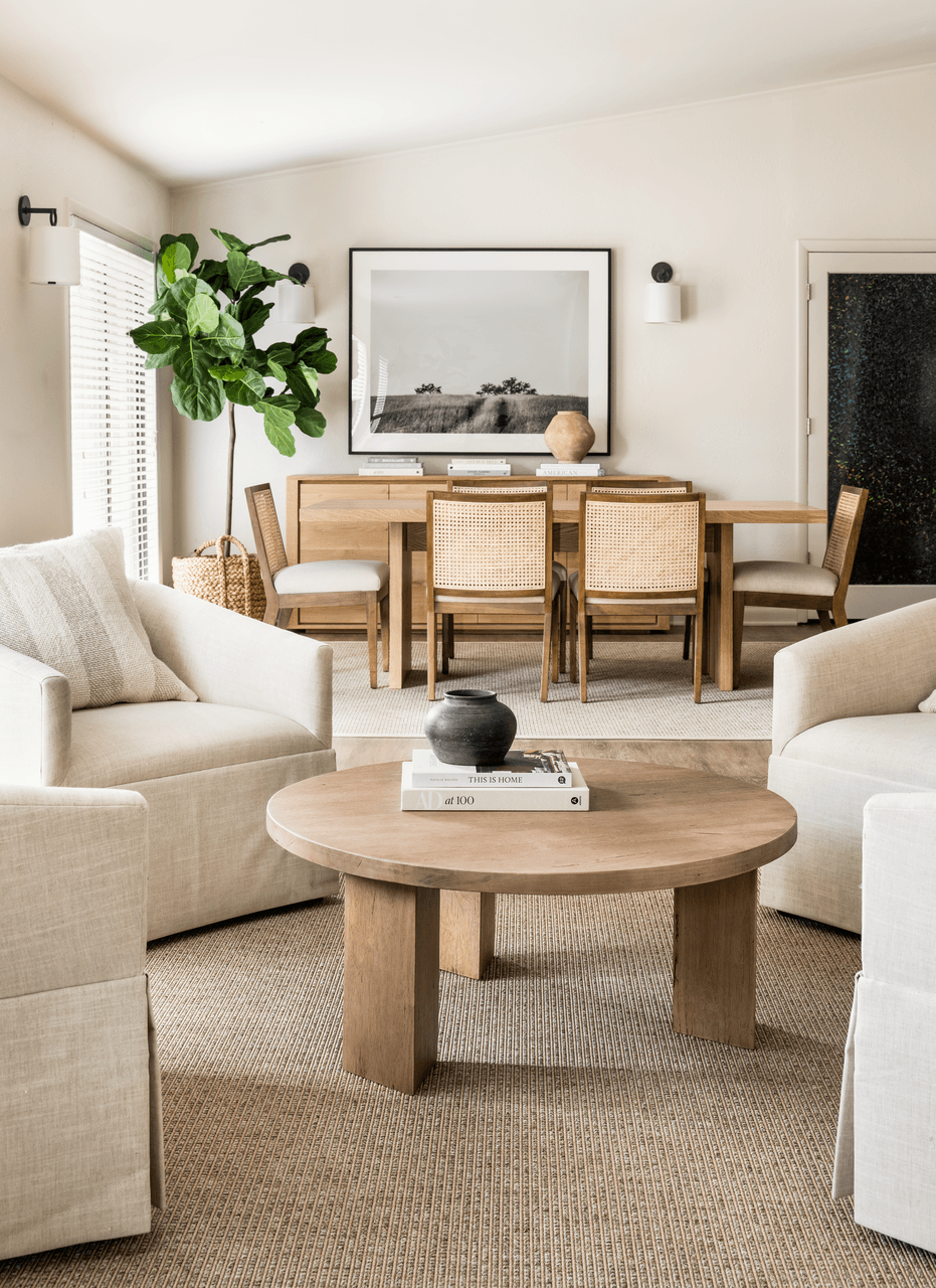 A living room with a wooden coffee table and white sofas.