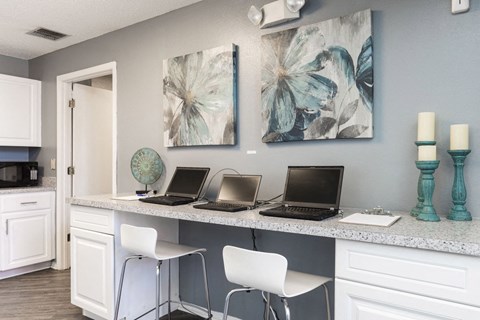 A kitchen with a white counter and two laptops on it.