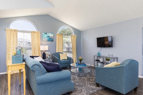 A living room with a blue couch and a yellow table.