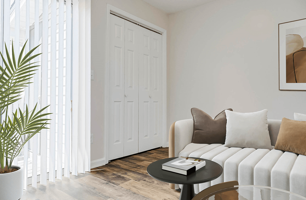 a living room with a white couch and a large window at Patriot Point Apartment Homes, Spring Lake, NC 28390