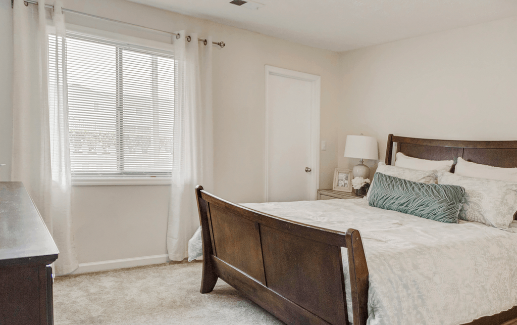 a bedroom with a large bed and a window at Patriot Point Apartment Homes, North Carolina, 28390