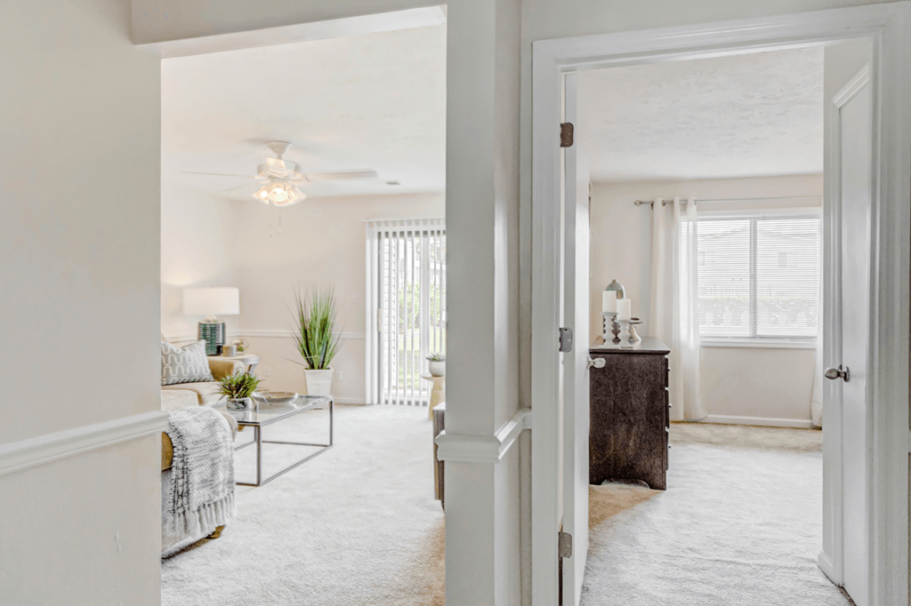 a living room with a bedroom and a ceiling fan at Patriot Point Apartment Homes, North Carolina 