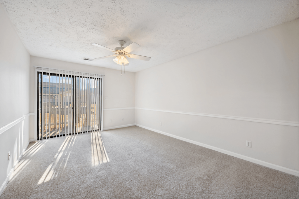an empty living room with a ceiling fan and window at Patriot Point Apartment Homes, Spring Lake, 28390 