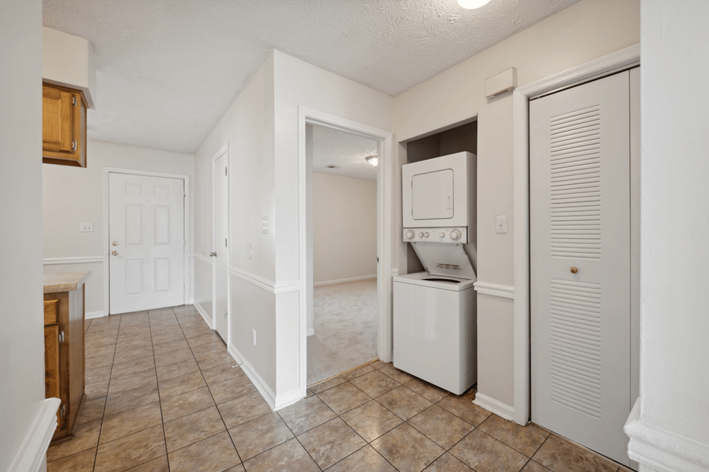 a kitchen with a washer and dryer and a door to a laundry room at Patriot Point Apartment Homes, Spring Lake, 28390 