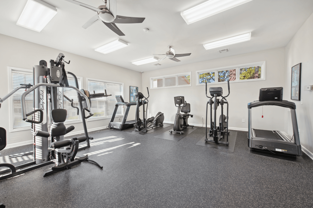 a gym with weights and cardio machines and a ceiling fan at Patriot Point Apartment Homes, Spring Lake, NC 28390