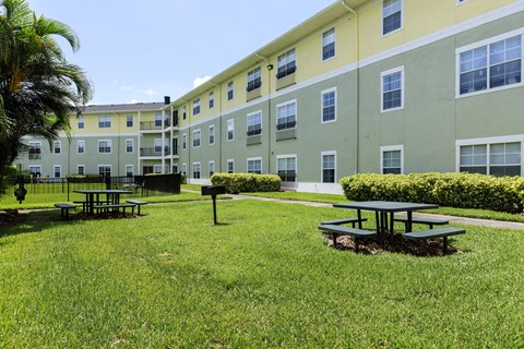 A green and yellow building with a picnic table in front.