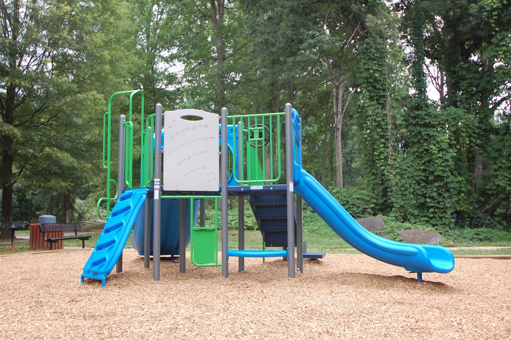 Playground jungle gym and playground slides in a bed of mulch