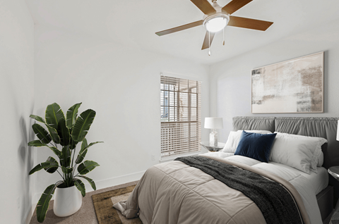 a bedroom with a bed and a ceiling fan