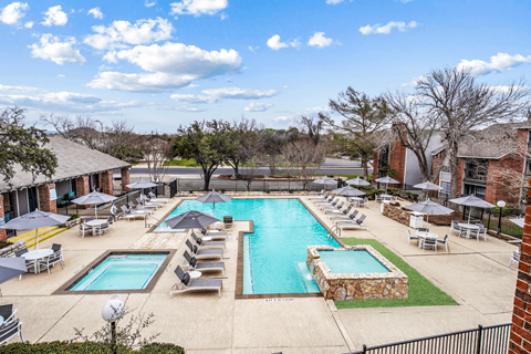 a pool with chairs and umbrellas at the resort on a sunny day