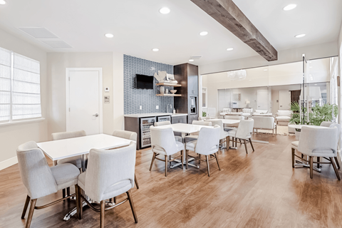 A modern dining room with a white table and chairs.