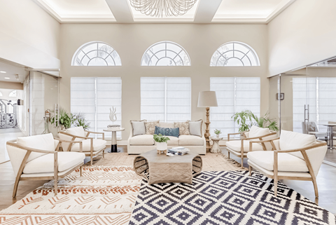A living room with a rug and chairs.