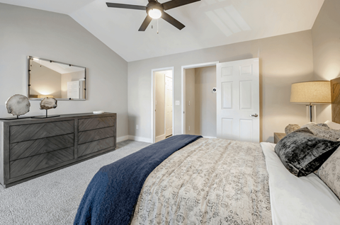 A bedroom with a large bed and a ceiling fan.