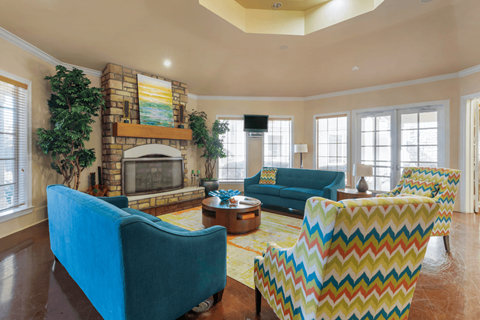 A living room with a blue couch and a yellow and red chair.