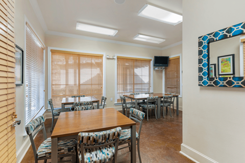 a dining room with tables and chairs and a painting on the wall