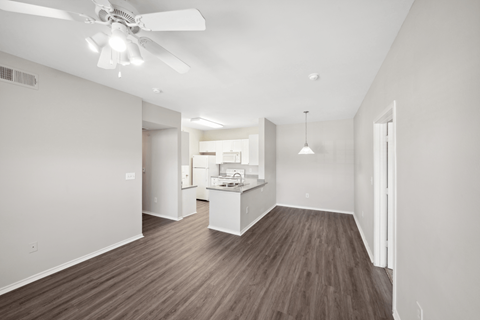 A room with a ceiling fan and wooden flooring.