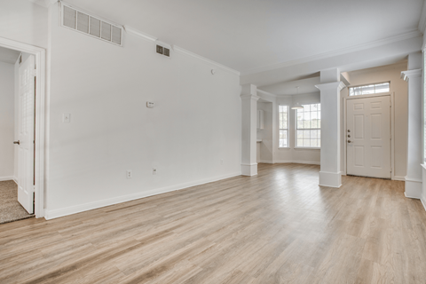 a bedroom with hardwood floors and white walls