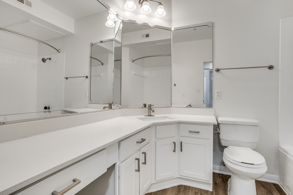 a bathroom with white cabinets and a white toilet