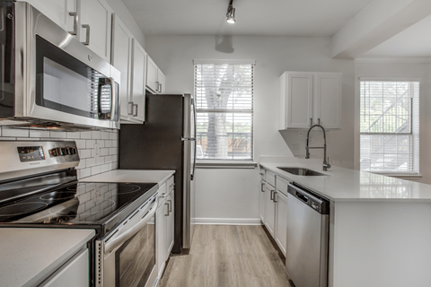 a kitchen with white cabinets and stainless steel appliances