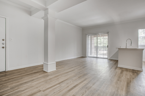 a bedroom with hardwood floors and white walls