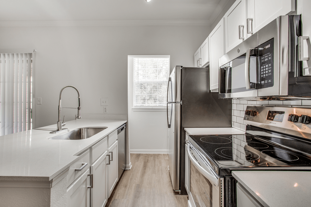 a kitchen with white cabinets and stainless steel appliances