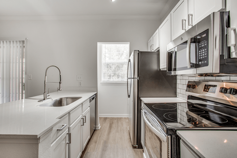 a kitchen with white cabinets and stainless steel appliances