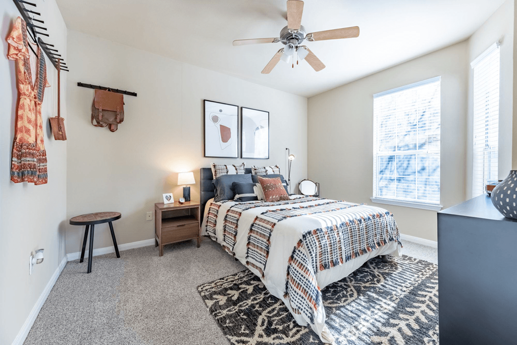 a bedroom with a bed and a ceiling fan
