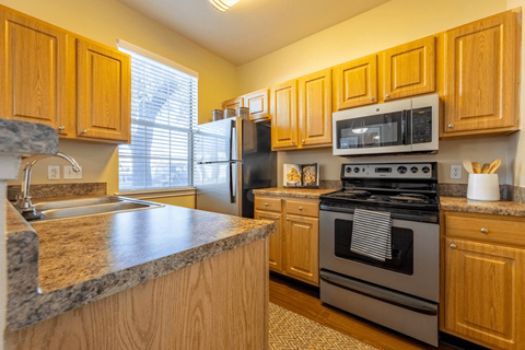 a kitchen with wooden cabinets and stainless steel appliances