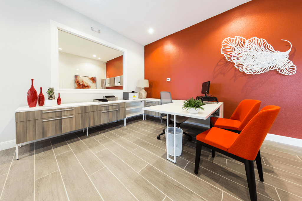 an office with orange chairs and a white bird on the wall