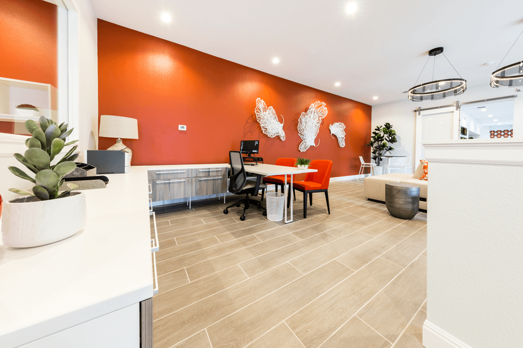 a desk with a computer in a room with orange walls
