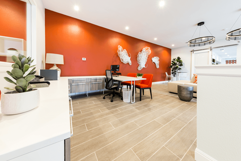 a desk with a computer in a room with orange walls