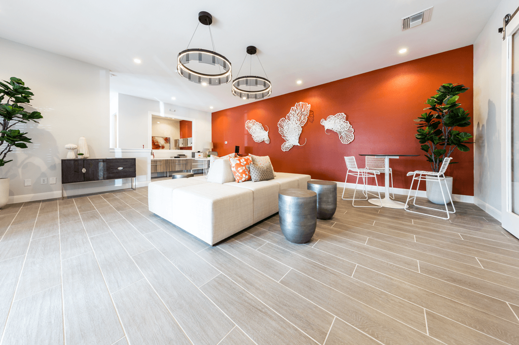 a living room with a white couch and a red wall