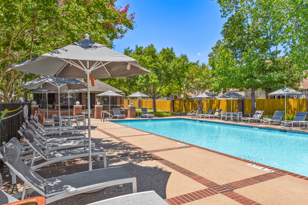 a pool with lounge chairs and umbrellas