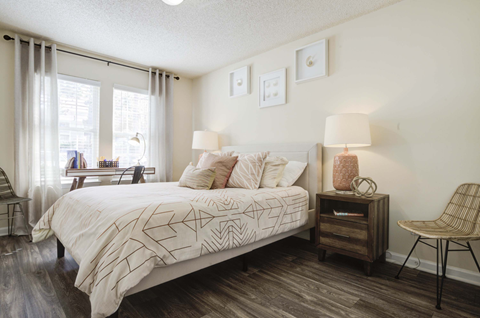 A bedroom with a large bed and a chair.