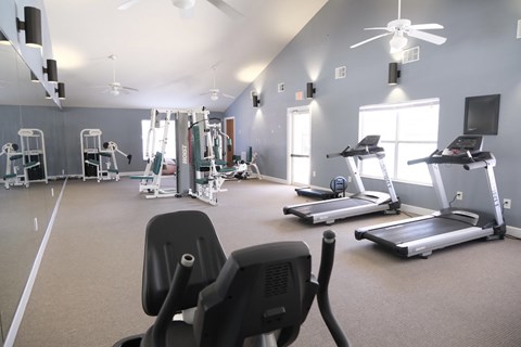 A gym with treadmills, elliptical machines, and other exercise equipment.