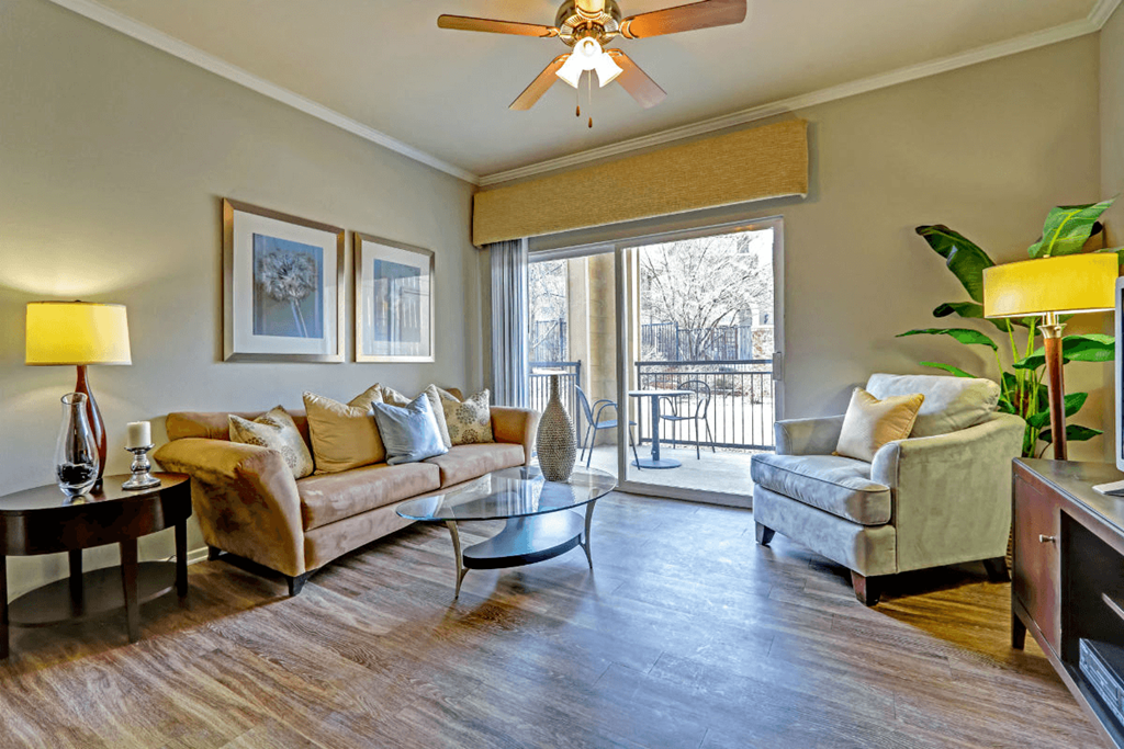 a living room with a ceiling fan and a sliding glass door