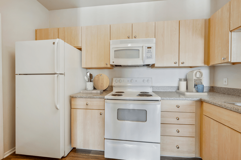 a kitchen with white appliances and wooden cabinets