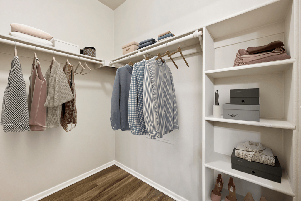 a spacious walk in closet with white walls and shelves