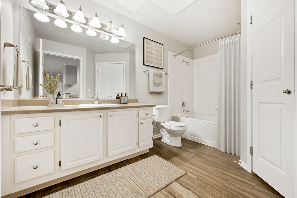 a bathroom with white cabinets and a white shower curtain