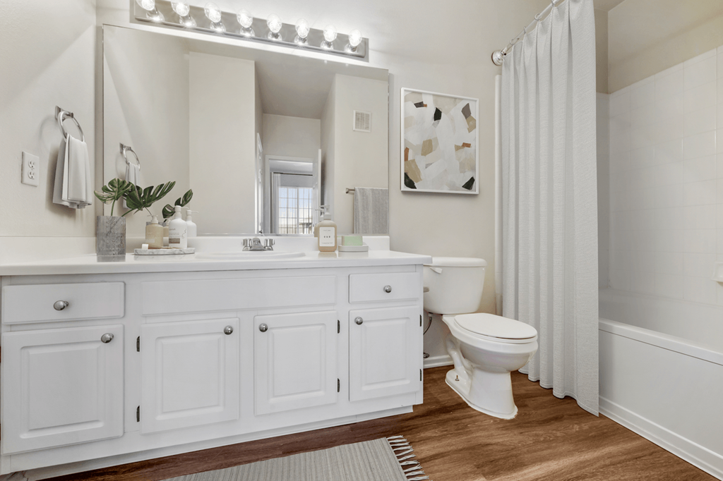 a bathroom with white cabinets and a white shower curtain