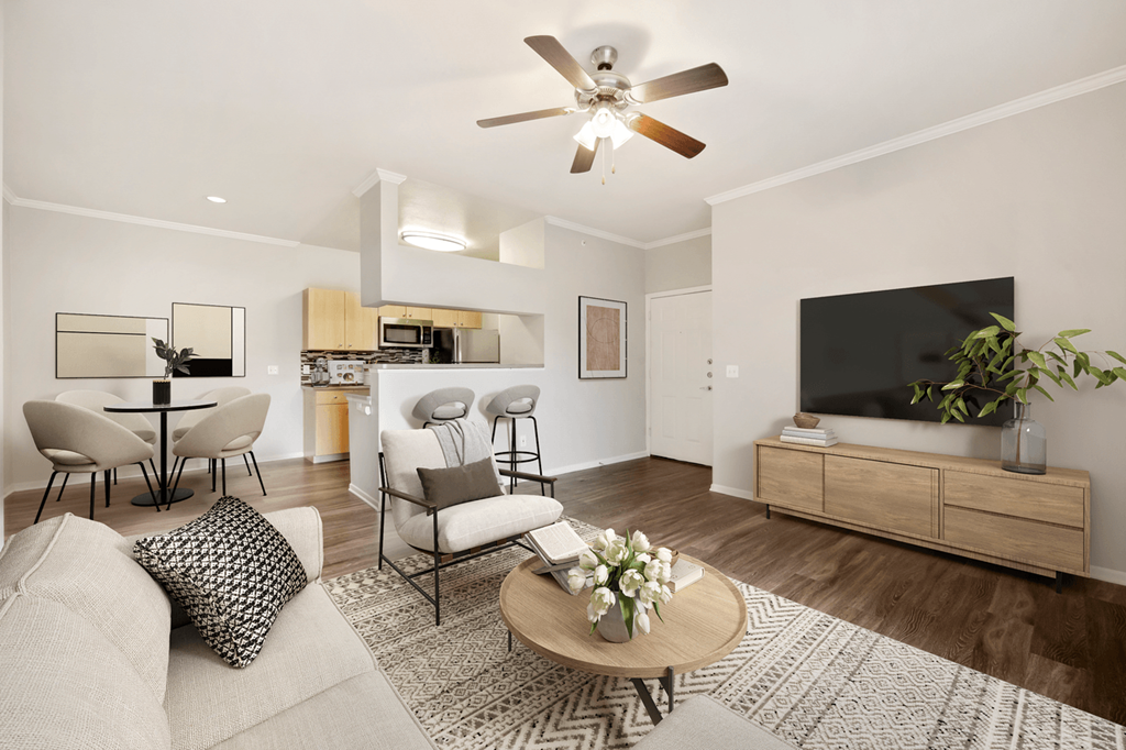 a living room with a ceiling fan and a flat screen tv